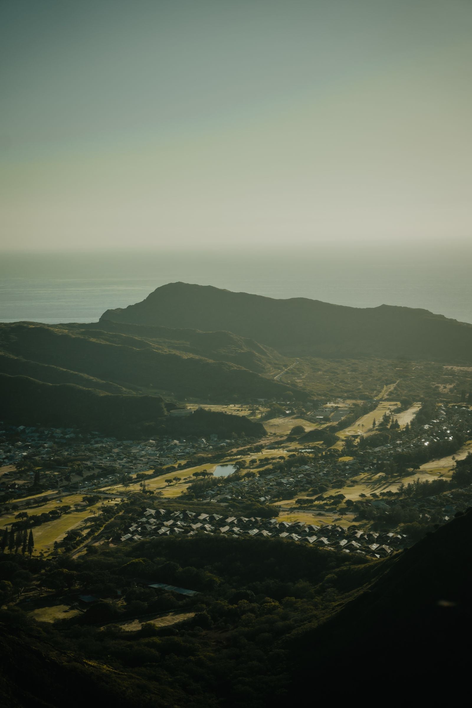Aerial view of a Hawaiian valley running from mountain ridges down to the coastline, illustrating the ahupuaʻa mountain-to-sea land division
