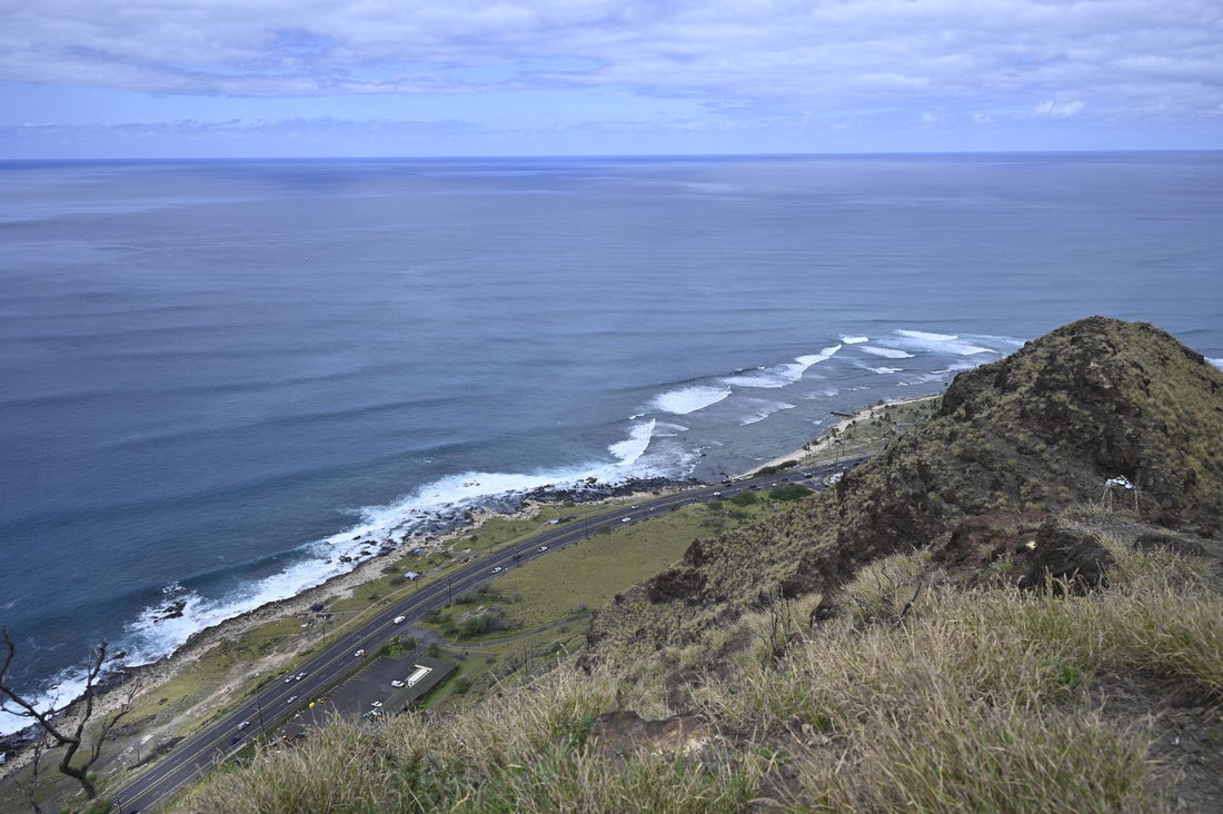 Aerial view of a coastal highway with cars along the Hawaiian shoreline