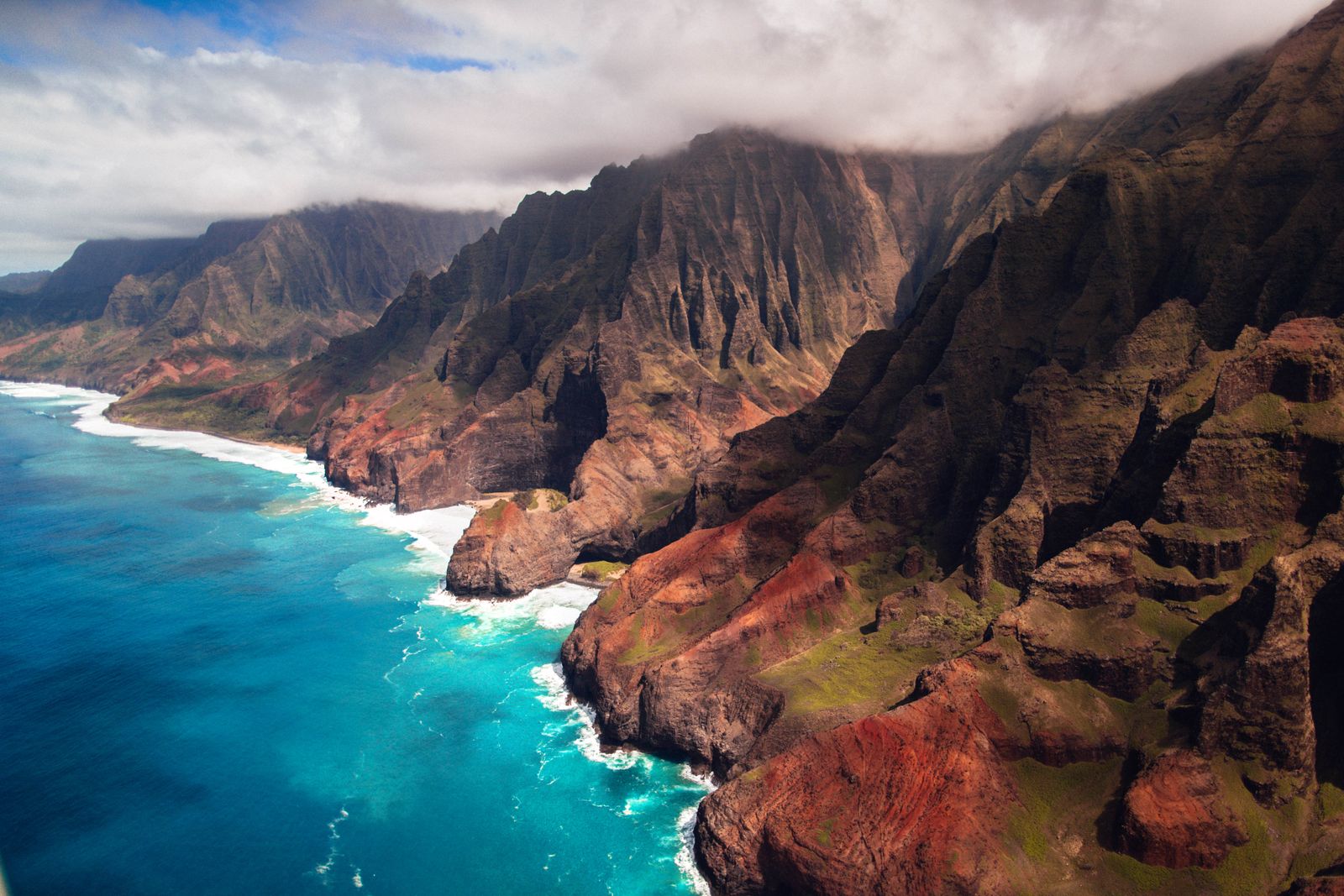 Aerial view of the Na Pali Coast cliffs and turquoise ocean, Kauaʻi, Hawaiʻi