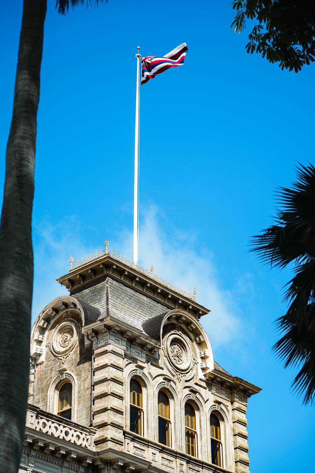 Iolani Palace tower with the Hawaiian Kingdom flag, historic seat of Hawaiian royalty in Honolulu