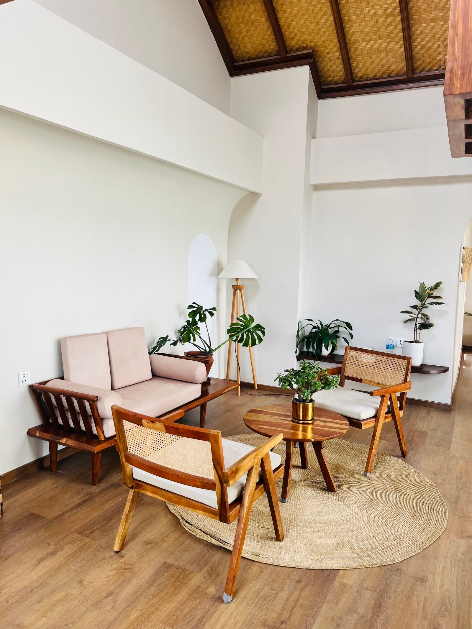 A bright, airy island-style living room with rattan chairs, wood floors, and tropical plants — Hawaiian home decor
