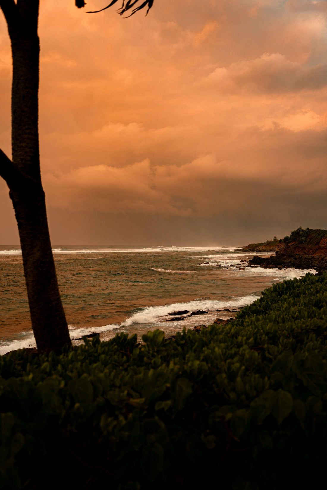 Dramatic orange sunset over the ocean at Paia Beach, Hawaii