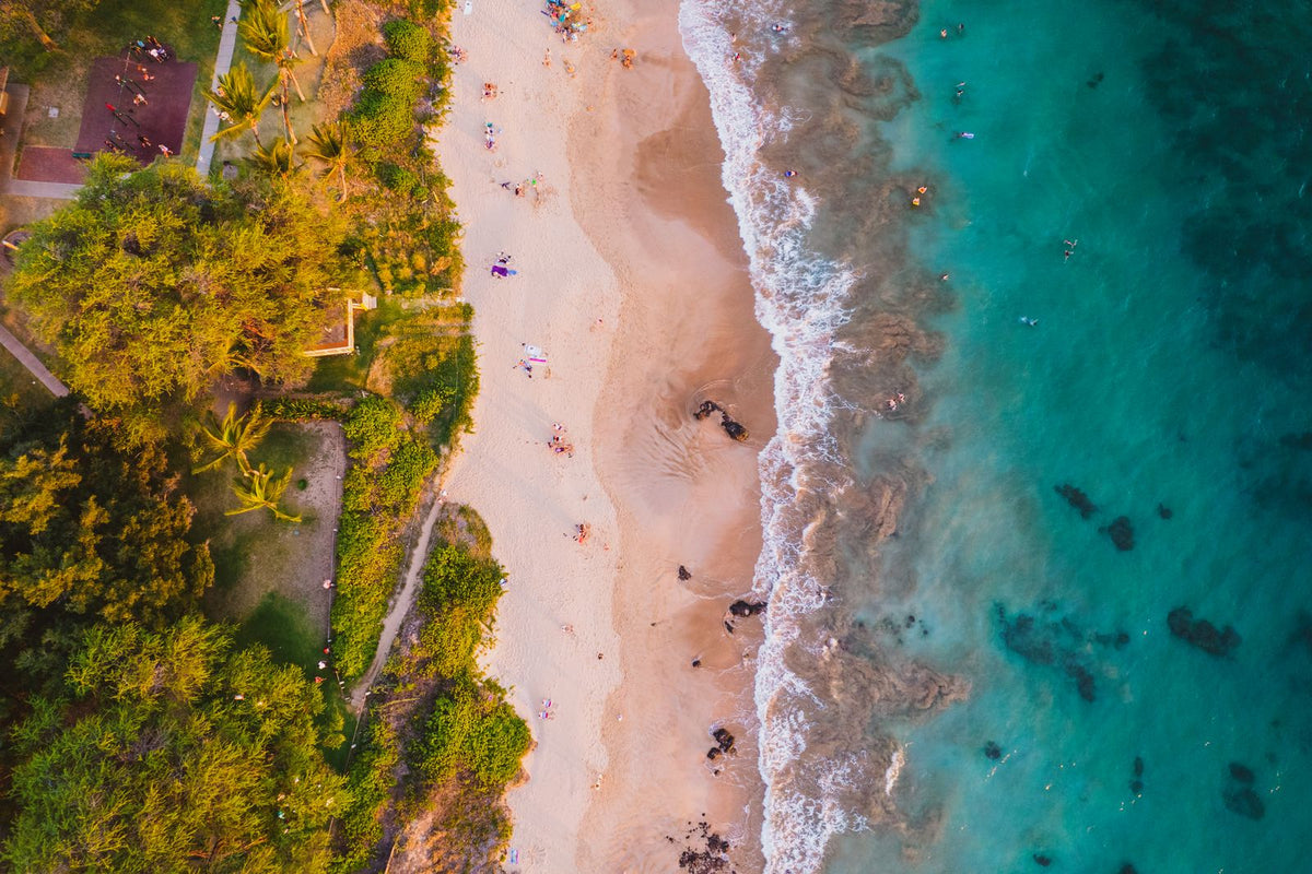 Aerial view of a golden sand beach and turquoise water on Maui, Hawaiʻi