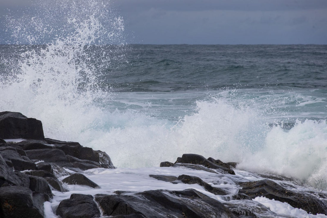 Waves break over black lava rock on the Hawaiian coast