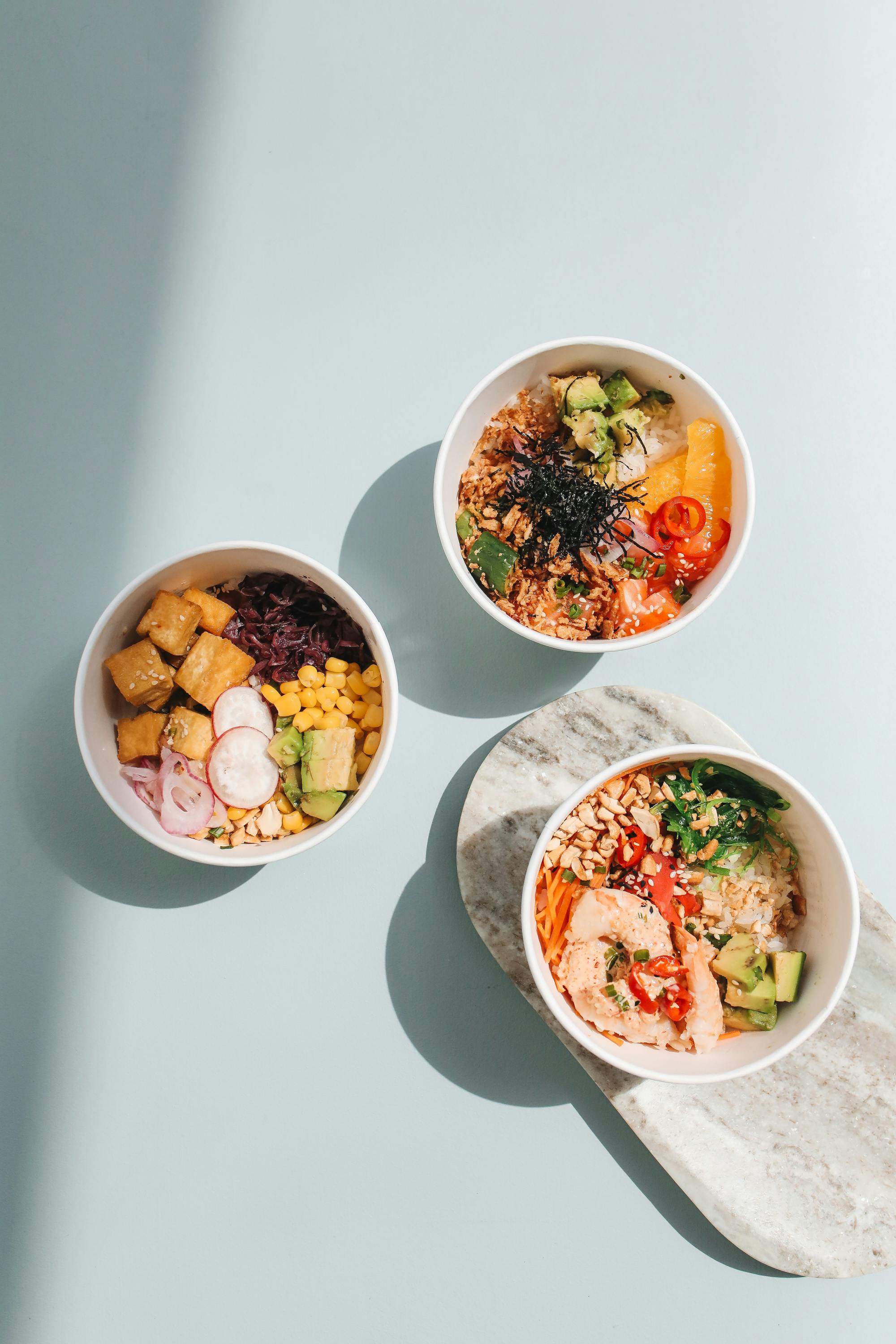 Three colorful Hawaiian poke bowls with fresh ahi, vegetables, and rice, Hawaiʻi
