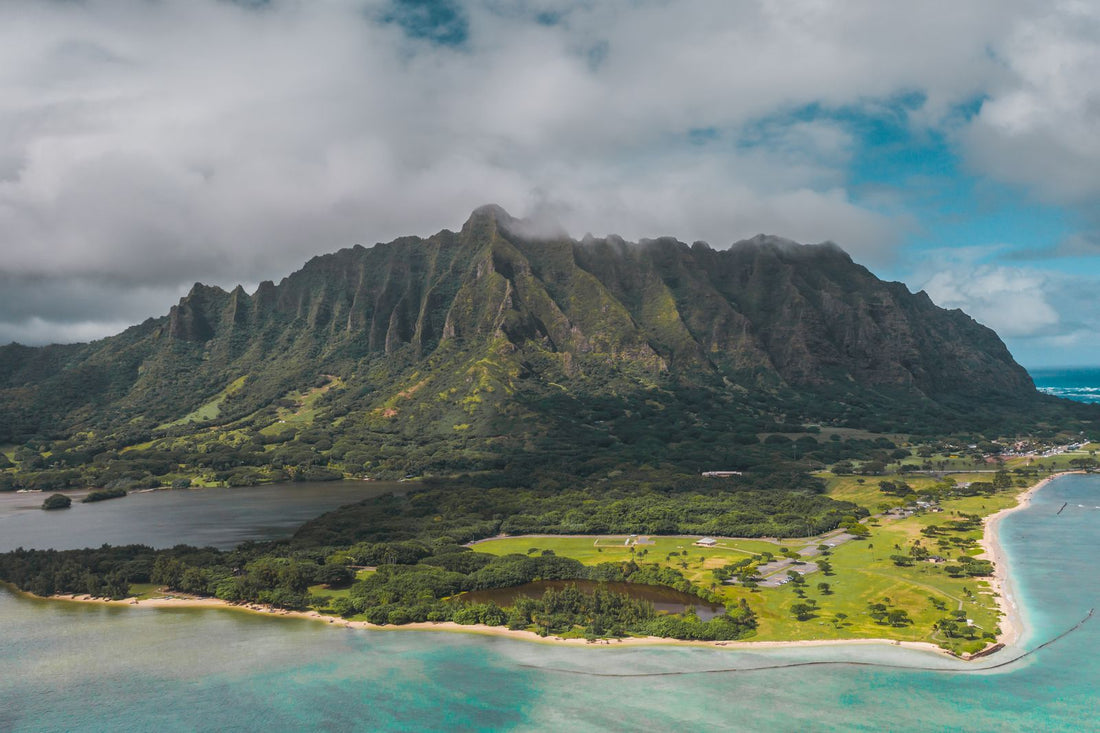 Aerial view of a lush Hawaiian island coastline with mountains and turquoise water, Hawaiʻi