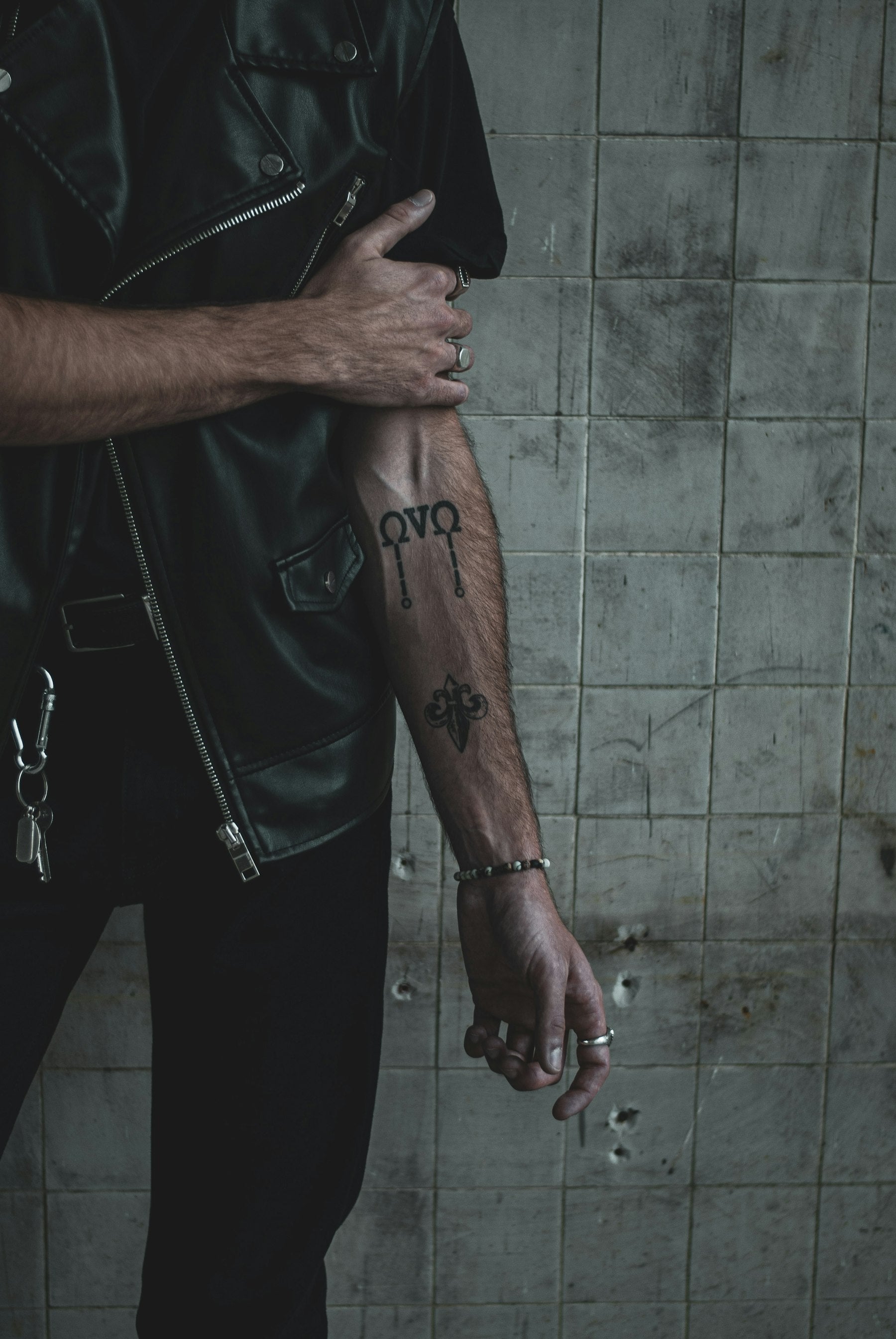 A forearm marked with bold black geometric banded tattoo patterns, echoing the lines of Hawaiian kākau