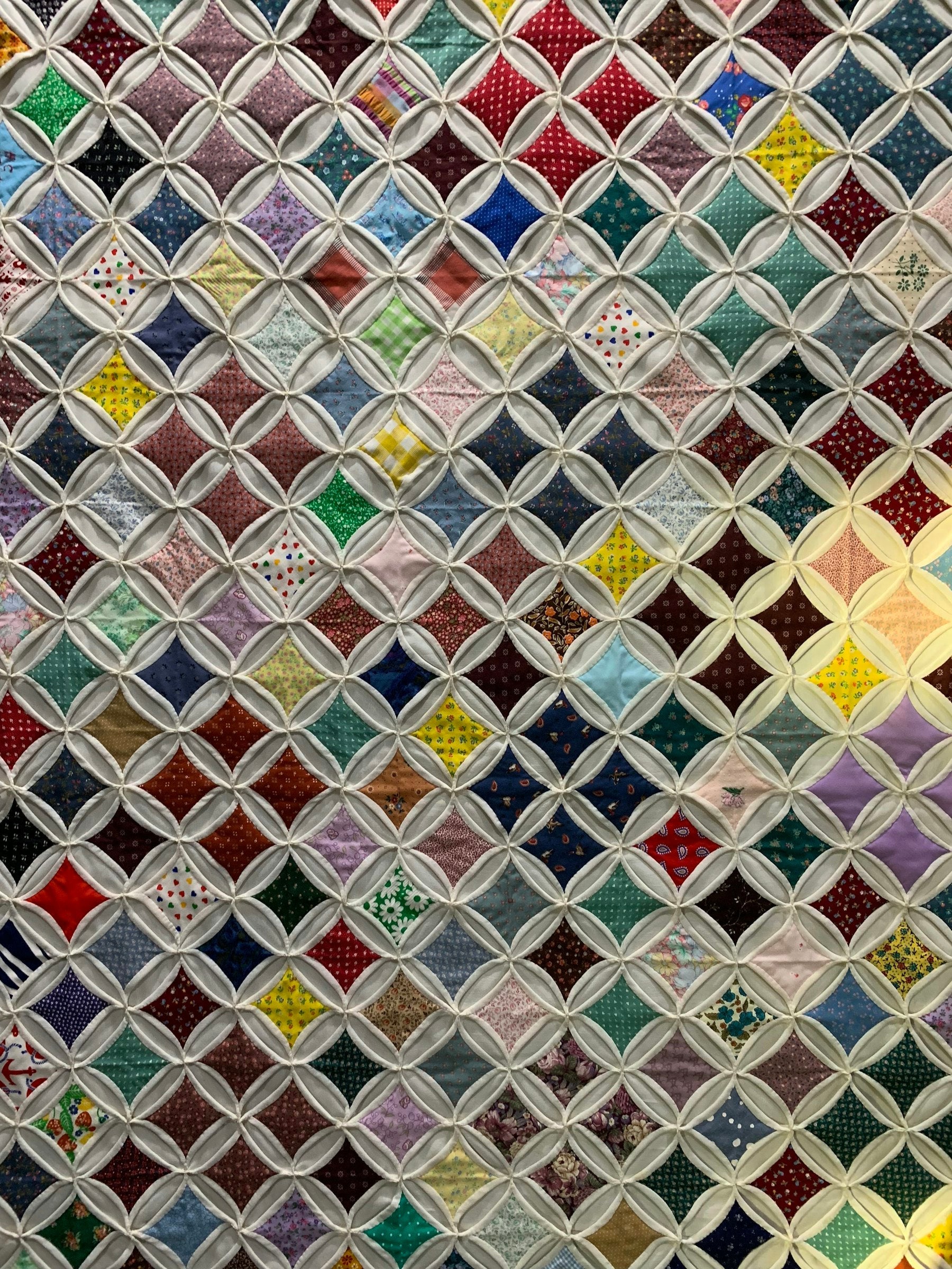 A close-up of a colorful handmade Hawaiian-style quilt with a bold appliqué pattern